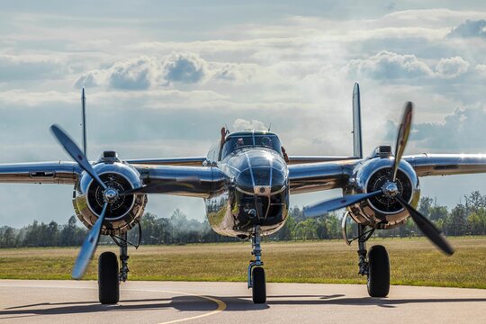 B24 bomber standing on road in background of greenery field and trees