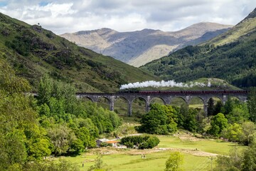 A steam train running across a viaduct in Scottish Highlands