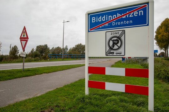 Sign with a red line that indicates the end of the village of Biddinghuizen in the Netherlands