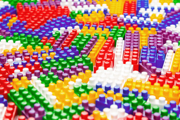 Abstract background texture of colored constructor blocks. Background of colorful plastic part of constructor. Pile of colored toy bricks.