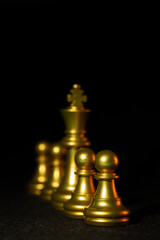chess pieces in gold on a black background