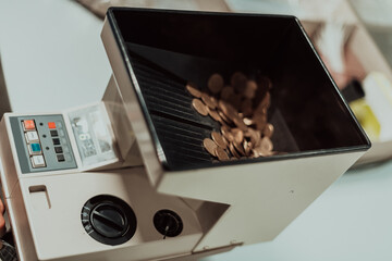 Bank employees using money counting machine while sorting and counting paper banknotes inside bank vault. Large amounts of money in the bank
