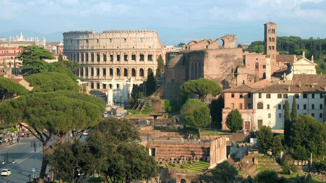 Street scape of the ancient centre of Rome, Italy. Colosseum in the distance, people and cars, greenery, old buildings