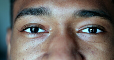 African man eyes close-up, black guy macro eye closeup staring camera