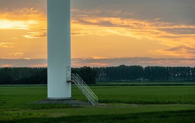 View of the base of wind turbine in dutch rural countryside at colorful sunset