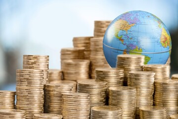 Globe and stack with gold coins. Money makes the world go round