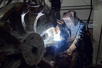 welder works with a large part in the factory