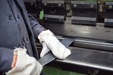a worker bends a plate with an industrial press