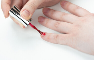 A woman begins to do a manicure on her little finger nail.