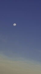 A moon rising against the clouds