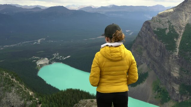 Female hiker enjoying the view of Lake Louise at the Devil's Thumb lookout in Banff National Park, Alberta, Canada. 
