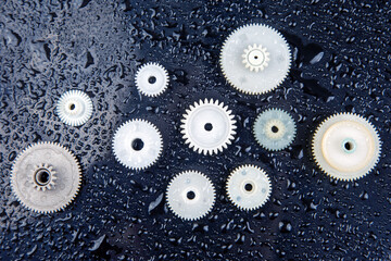 white plastic gears on a dark background. connection mechanism details. subject of movement