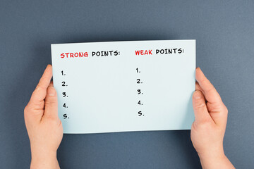 Holding a paper in the hands, list of weak and strong points, analysis of skills, improvement and...