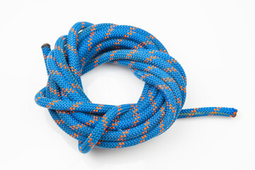 durable colored rope for climbing equipment on a white background. coil of braided cable. item for tourism and travel