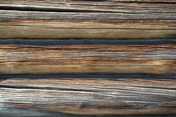 Background.The wall of an old wooden house made of logs.