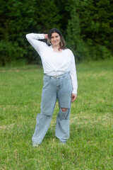 Fototapeta premium Portrait of a fat woman in a white blouse in the park.A walk in the park.