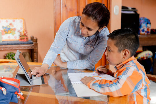 Hispanic Mom Helping Her Little Son Do Her Homework -homeschooling-young Latin Mother And Her Son Learn Online With Tablet At Home.