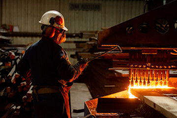 Worker checking a CNC oxy fuel cutting machine in a factory