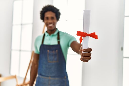 Young African American Artist Man Holding Diploma At Art Studio.