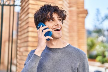 Young hispanic man smiling confident talking on the smartphone at street