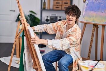 Fototapeta na wymiar Young hispanic man artist smiling confident drawing at art studio