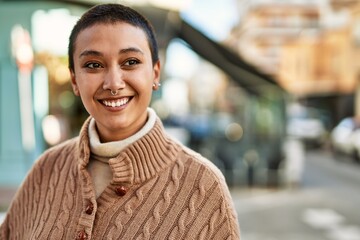 Beautiful hispanic woman with short hair smiling happy outdoors