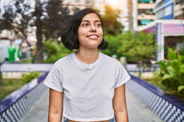 Fototapeta na wymiar Young latin woman smiling confident standing at street