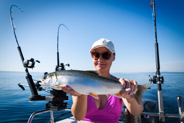 Happy women angler with arctic char
