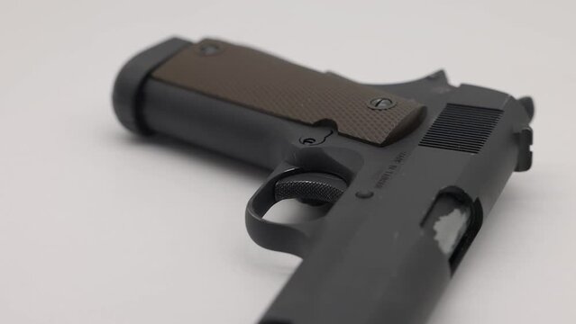 Black  colored 45 automatic hand gun  rotating on white background - BB gun replica