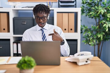 African man with dreadlocks wearing call center agent headset pointing finger to one self smiling happy and proud