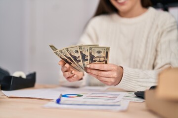 Young woman ecommerce business worker counting dollars at office