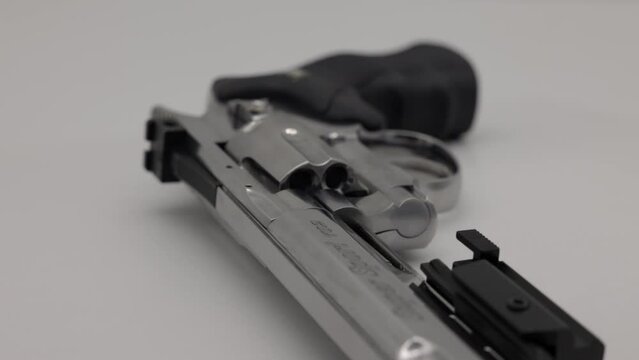 Rotating silver colored revolver gun on white backdrop with long barrel - co 2 BB Gun