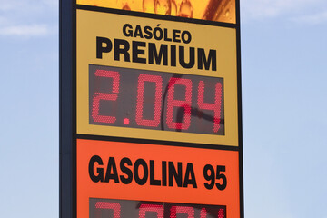 Close-up of a gas station sign that reads fuel prices for cars
