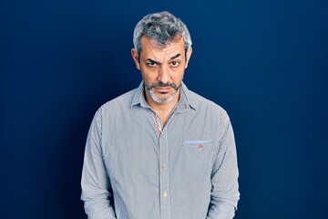 Handsome middle age man with grey hair wearing business shirt skeptic and nervous, frowning upset because of problem. negative person.