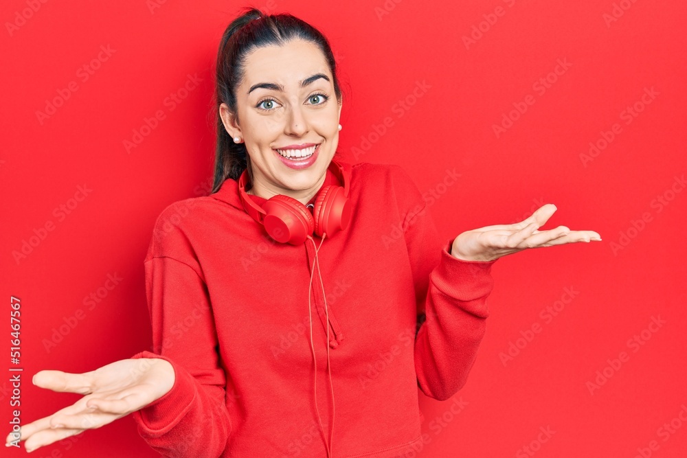 Canvas Prints Beautiful woman with blue eyes wearing gym clothes and headphones clueless and confused expression with arms and hands raised. doubt concept.