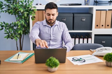 Naklejka premium Young hispanic man business worker using laptop working at office