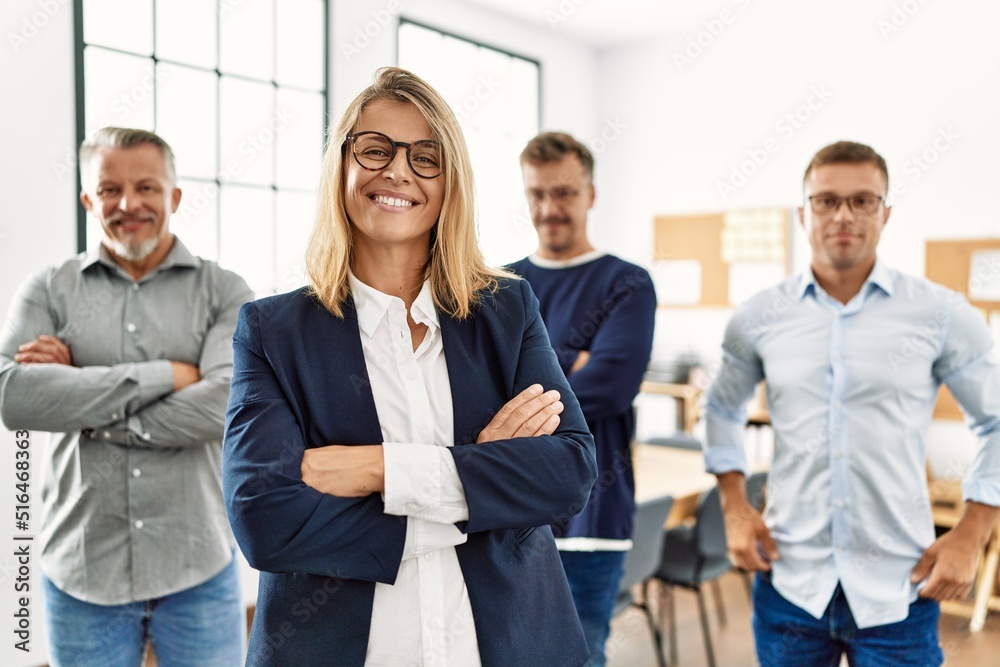 Sticker Middle age businesswoman smiling with arms crossed gesture standing with work partners at the office.