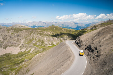 Combi van aménagé jaune sur une route de montagne, Alpes Françaises