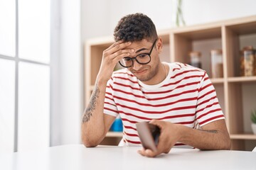 African american man holding empty wallet sitting on desk at home