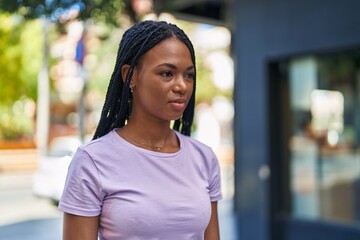 African american woman looking to the side with serious expression at street