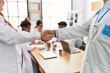 Fototapeta premium Group of doctor clapping to partners handshake in a medical meeting at the clinic office.