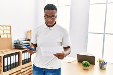 Young african man working using smartphone at business office