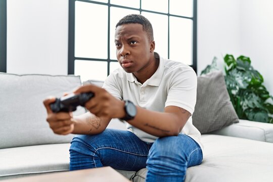 Young african man playing video games at home