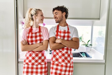 Young couple smiling happy standing with arms crossed gesture at kitchen.