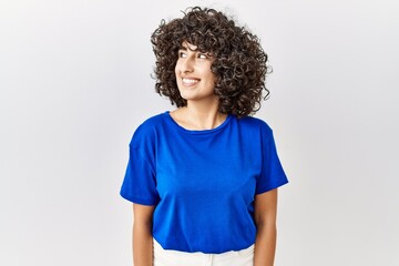 Young middle eastern woman standing over isolated background smiling looking to the side and staring away thinking.