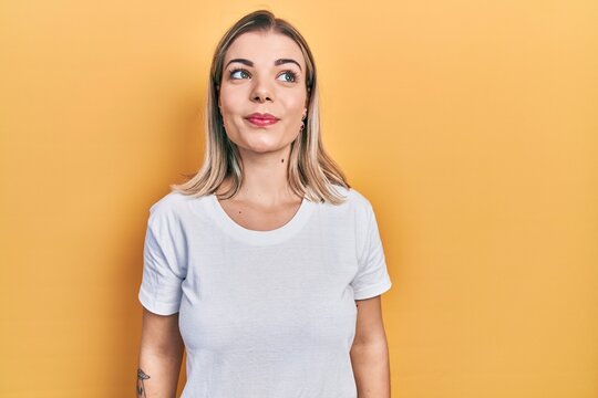 Beautiful Caucasian Woman Wearing Casual White T Shirt Smiling Looking To The Side And Staring Away Thinking.