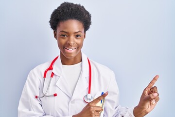 African american woman wearing doctor uniform and stethoscope smiling and looking at the camera...