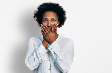 African american woman with afro hair wearing casual white t shirt shocked covering mouth with hands for mistake. secret concept.
