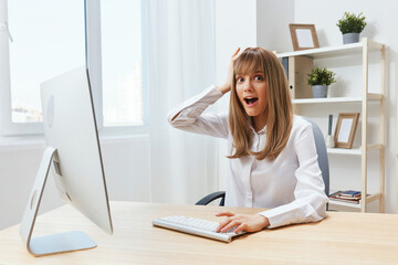 Excited adorable blonde businesswoman typing answer for client look at camera touch head sitting at workplace in modern office. Happy employee work on computer online in support service. Copy space