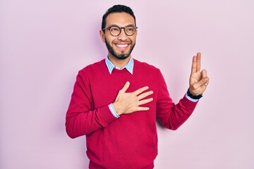 Hispanic man with beard wearing business shirt and glasses smiling swearing with hand on chest and...